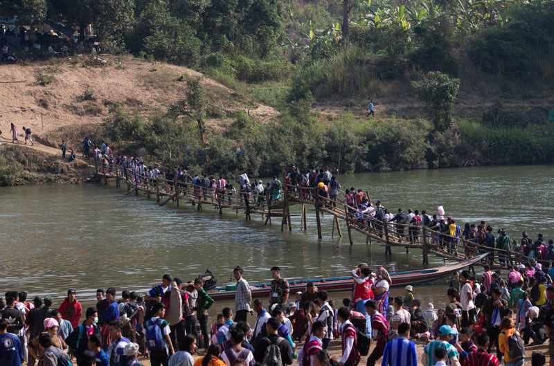 Karen refugees walk on a bamboo bridge while crossing a river back to Thailand after the 70th anniversary of Karen National Revolution Day at the rebel jungle stronghold in Karen State, Myanmar, 31 January 2019. Photo - Rungroj Yongrit/EPA