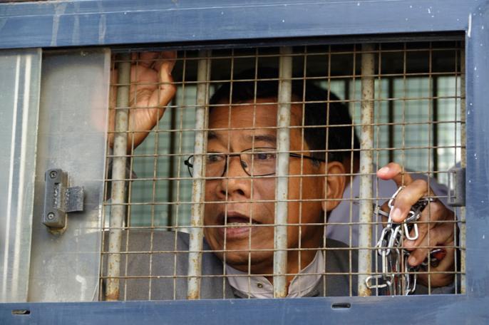 Dr. Aye Maung, Ann Township MP and former Arakan National Party leader, speaks to the media while being escorted out of court by police officers after his hearing at Sittwe court in Sittwe, Rakhine, Myanmar, 19 March 2019. Photo: Nyunt Win/EPA