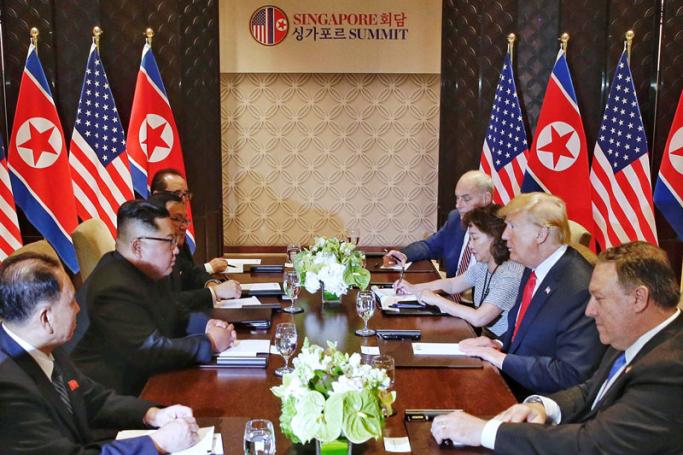 US President Donald J. Trump (2-R) and North Korean leader Kim Jong-un (2-L) stare at each other during the expanded bilateral meeting as part of the historic summit at the Capella Hotel on Sentosa Island, Singapore, 12 June 2018. The summit marks the first meeting between an incumbent US President and a North Korean leader. Photo: EPA-EFE