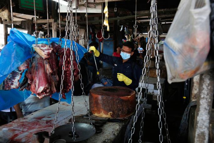 A staff member of the Yangon City Development Committee disinfects Pazontaung market, as a preventive measure against the spread of the COVID-19 novel coronavirus, in Yangon on March 21, 2020. Photo: Sai Aung Main/AFP
