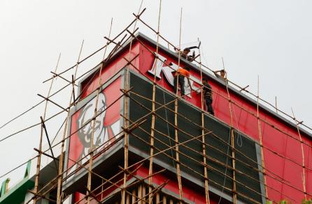 Workers on scaffolding prepares the logo of the KFC first branch restaurant in Yangon, Myanmar, 22 June 2015. EPA/LYNN BO BO