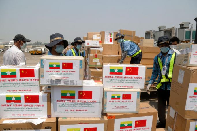 Airport staff unload medical supplies brought by Chinese medical team on arrival at Yangon International Airport in Yangon on April 8, 2020 to aid Myanmar in its effort to combat the COVID-19 novel coronavirus. Sai Aung Main / AFP