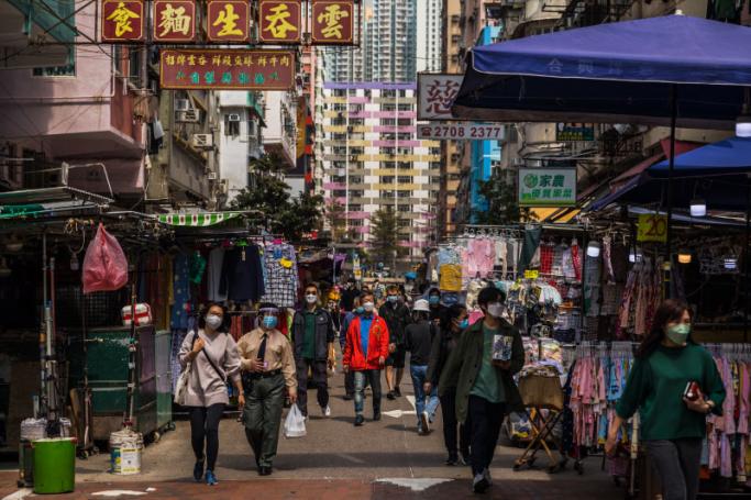 People wearing face masks as a preventive measure against the Covid-19 coronavirus walk on a street in Hong Kong on March 2, 2022. Photo: AFP