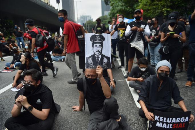 A man holds a picture of Chief Commissioner of the Malaysian Anti-Corruption Commission (MACC) Azam Baki during an Arrest Azam Baki rally in Kuala Lumpur on January 22, 2022. Arif Kartono / AFP