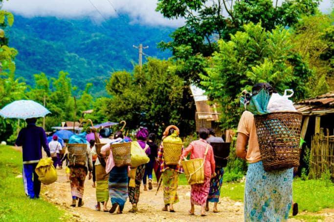 Women walking after receiving food donations in the Mong Paw area in Shan state, as fighting has intensified in the region between the military and various ethnic armed groups in eastern Myanmar since the February military coup. Photo: MNWM / AFP