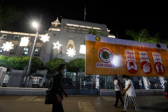 People walk past the Christmas Lights decoration during Christmas Eve at the Yangon City Hall in Yangon, Myanmar, 24 December 2020. Photo: Nyein Chan Naing/EPA