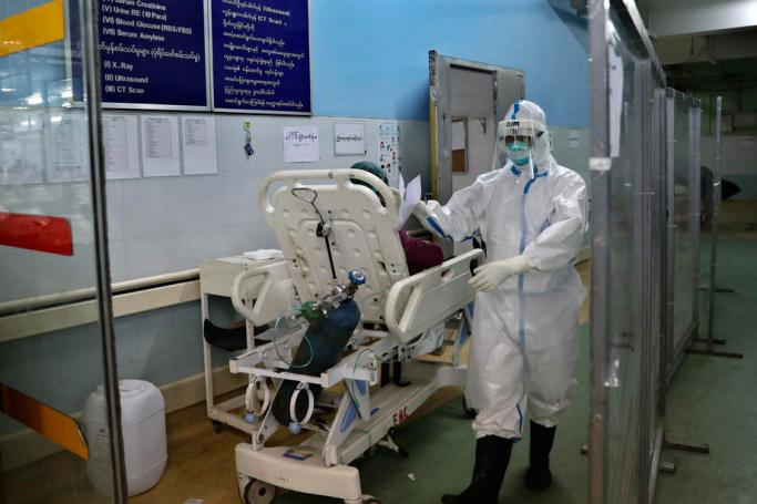 A medical worker wearing PPE (personal protective equipment) prepares to move a patient from a fever room at emergency department of Yangon General Hospital, in Yangon, Myanmar, 01 January 2021. Photo: Lynn Bo Bo/EPA