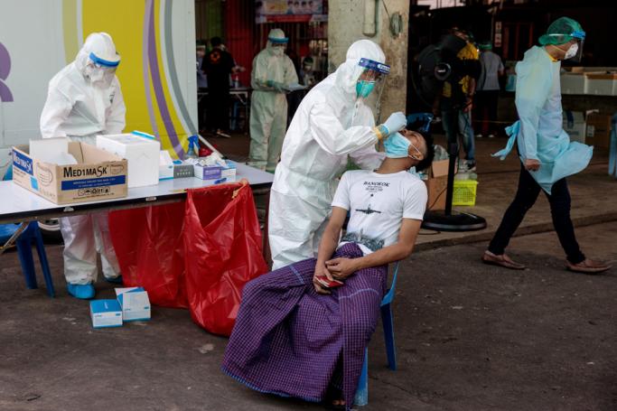 Medical officials collect a nose swab sample to test for the COVID-19 coronavirus at a seafood market in Samut Sakhon on December 19, 2020 after some cases of local infections were detected and linked to a vendor at the market. Photo: Jack Taylor/AFP)