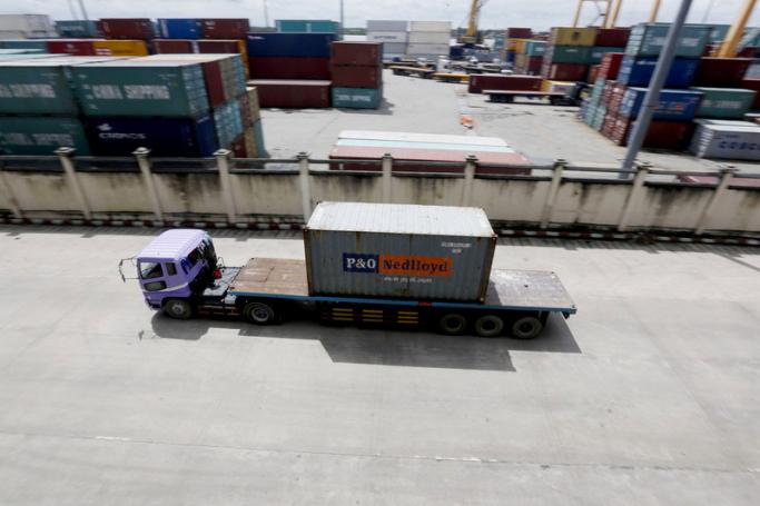 A truck carries a container at the Ahlone international terminal port in Yangon. Photo: EPA