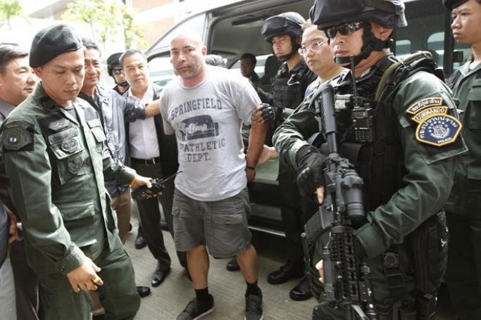 Cracking down on the illegal drug trade in the Golden Triangle is a tough call. Alleged American drug trafficker Joseph Manuel Hunter (C) is escorted by Thai commandos as he arrives to board a chartered jet for extradition to the USA at Don Mueang airport in Bangkok, Thailand, September 27, 2013. Photo: Narong Sangnak/EPA

