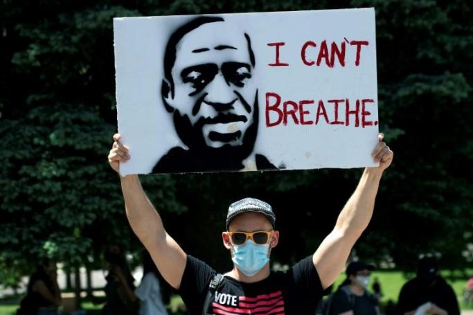 A demonstrator holds up a poster with a rendition of George Floyd on May 30 in Denver (AFP Photo/Jason Connolly) 