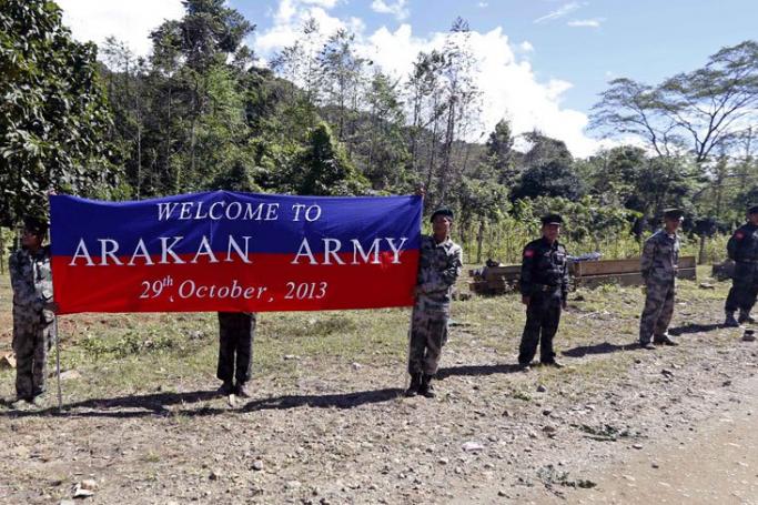 Arakan Army soldiers holding a banner of welcome for the convoy of Ethnic Armed Organizations leaders while on its way from Myitkyina to Laiza, Kachin State, Myanmar, October 29, 2013. Photo: Nyein Chan Naing/EPA
