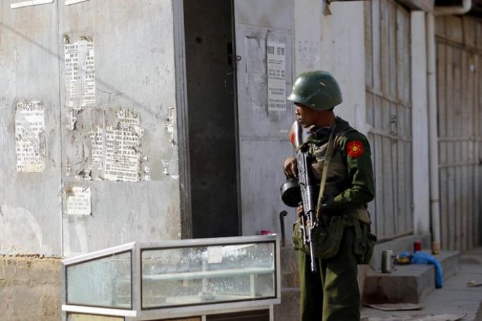 A government soldier takes a position at the corner of a street in self-administered Kokang capital Laukkai, northern Shan State, Myanmar, February 16, 2015. Photo: Lynn Bo Bo/EPA
