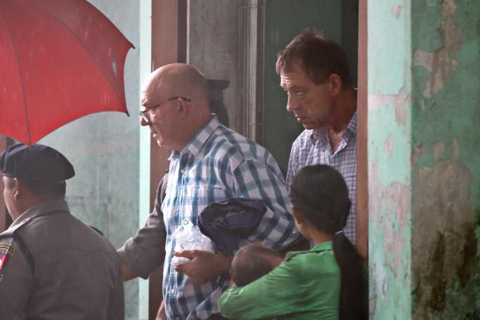 Australian publisher Ross Dunkley (C-L) followed by his partner John McKenzie (C-R) leaves the court after the first appearance on his trial at Bahan township court in Yangon, 15 June 2018. Photo: Lynn Bo Bo/EPA