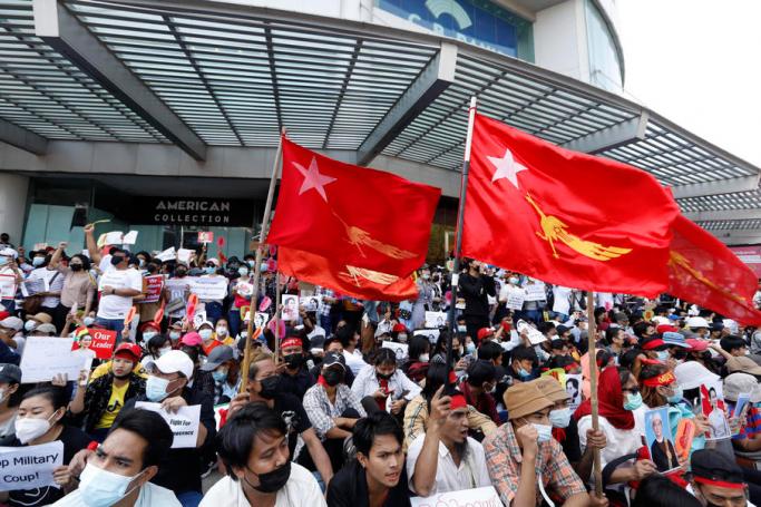 Demonstrators hold the National League for Democracy (NLD) party flags and placards during a protest against the military coup at the Hledan junction in Yangon, Myanmar, 10 February 2021. Photo: Nyein Chan Naing/EPA