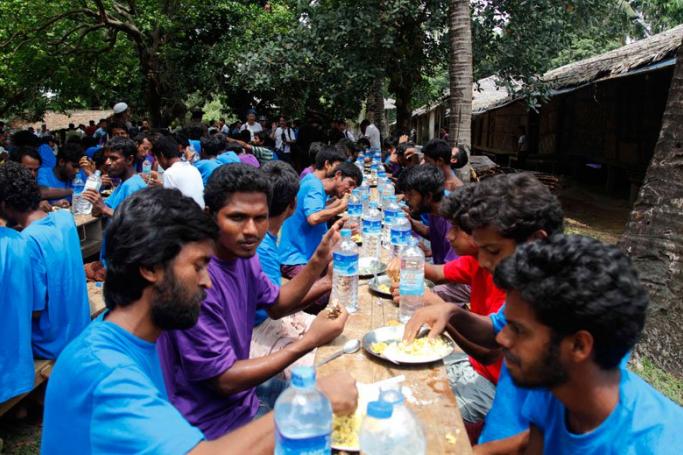 Rohingya Muslims from Bangladesh rescued by the Myanmar navy eat food together at a temporary refugee camp in the village of Aletankyaw in the Maungdaw township of northern Rakhine state, Myanmar, 23 May 2015. EPA/NYUNT WIN
