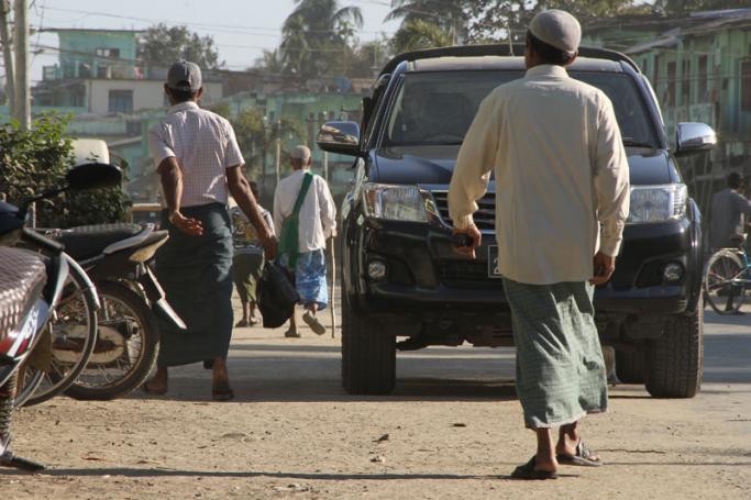 Buddhist and Muslim men walk in Maungdaw town market in the restive Rakhine state on January 24, 2019. Photo: Richard Sargent/AFP