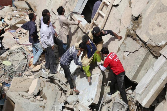 Pakistani civilians rescue victims from the rubble, after a building collapsed in Karachi, Pakistan, 05 March 2020. Photo: EPA