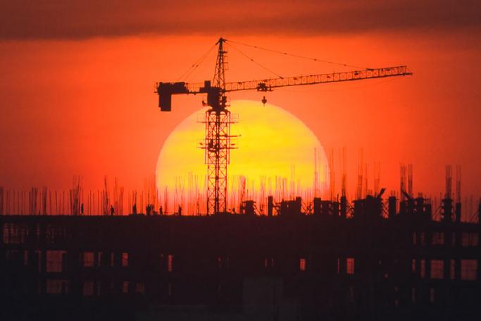 Labourers work at building construction site during a sunset in Yangon. Photo: Ye Aung Thu/AFP