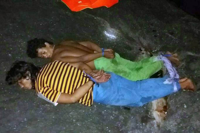 Two Cambodian fishermen accused of raping two French female tourists and assaulting their two male companions, lie cuffed in Koh Kut island, Thailand's Trat province, 28 February 2016.  Photo: EPA
