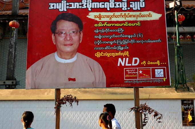 People walk in front of a campaign advertising of the National League for Democracy (NLD) party for the upcoming by-election in the country, in downtown Yangon, Myanmar, 29 March 2017. Photo: Lynn Bo Bo/EPA
