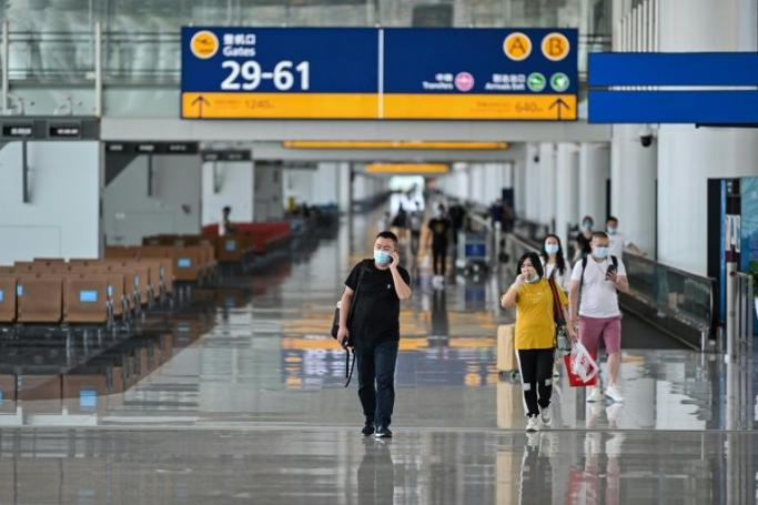 Passengers wear masks as they walk through Tianhe Airport in Wuhan (Photo: AFP/File)