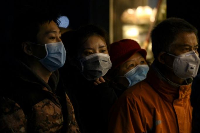People wearing protective facemasks queue for food in Shanghai (AFP Photo/NOEL CELIS)