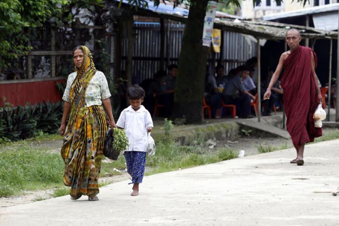 Buddhist monk (R) and Hindu woman with her daughter walk on the road in Maungdaw township, Rakhine State, western Myanmar, 07 September 2017. Photo: Nyein Chan Naing/EPA
