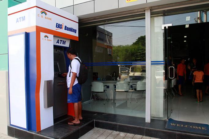 A man uses the ATM of a Co-operative Bank in Yangon. Photo: EPA
