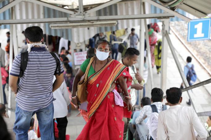 Passengers use protective mask at a local railway station in Kolkata, Eastern India, 14 March 2020. Photo: EPA
