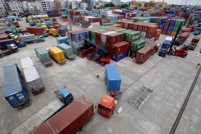Trucks and forklifts are moving containers at Aisa World port in Yangon. Photo: Lynn Bo Bo/EPA