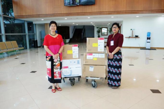 Singapore Ambassador to Myanmar Vanessa Chan (left) handing over Singapore’s contributions to Myanmar National Health Laboratory director Htay Htay Tin. Photo: MFA