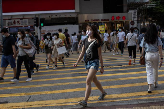 A woman wearing a face mask crosses an intersection in Hong Kong, China, 27 July 2020.  Photo: EPA