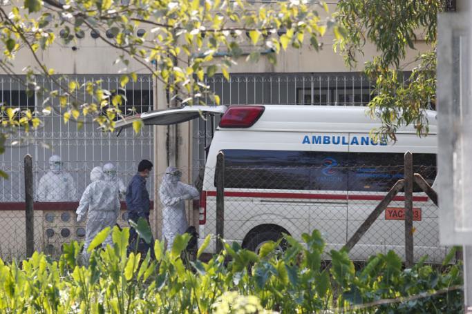 Medical staff wearing protective suits stand behind a Yangon airport ambulance believed to be carrying a sick plane passenger at the Wai Ba Gi hospital in Yangon on January 31, 2020.  Photo: AFP