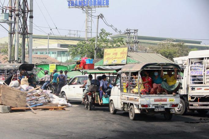 People in cars and trucks flee the Hlaing Tharyar township in Yangon on March 16, 2021, as security forces continue a crackdown on protests in the area against the military coup. Photo: AFP