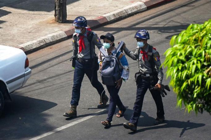 Police arrest Myanmar Now journalist Kay Zon Nwe in Yangon on February 27, as protesters were taking part in a demonstration against the military coup. Photo: AFP