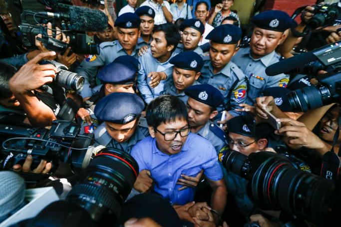 Reuters' journalists Wa Lone (C, front) and Kyaw Soe Oo (C, back) are escorted by police as they leave the court after their first trial in Yangon, Myanmar, 10 January 2018. Photo: Lynn Bo Bo/EPA-EFE

