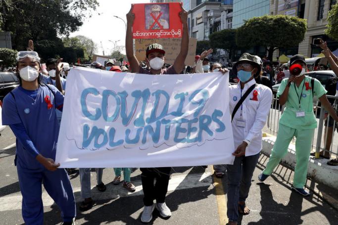 (File) Health workers hold a banner during a protest against the military coup, in Yangon, Myanmar, 10 February 2021. Photo: EPA