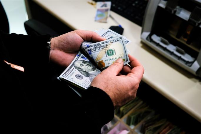 A currency exchange office worker counts US dollars at an exchange office in Istanbul, Turkey, 14 April 2023. Photo: EPA
