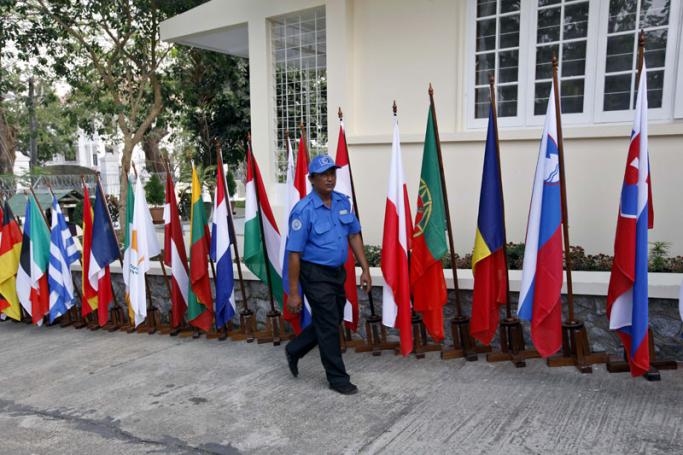 A security personnel walks past European countries flags during the opening ceremony of European Union office in Yangon, Myanmar, 28 April 2012. Photo: Nyein Chan Naing/EPA
