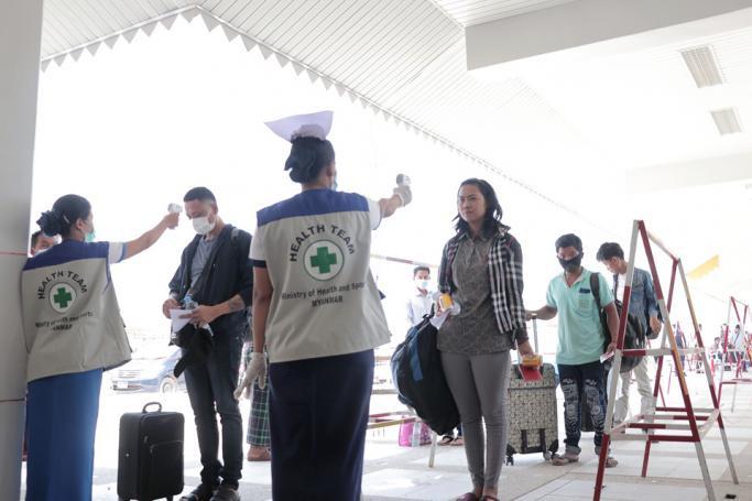 (File) People have their temperatures checked amid concerns over the spread of the COVID-19 coronavirus at the immigration post in Myawaddy near the Thai border on March 23, 2020, as thousands of people crossed from Thailand as the border crossings were due to close because of the growing pandemic. Photo: AFP