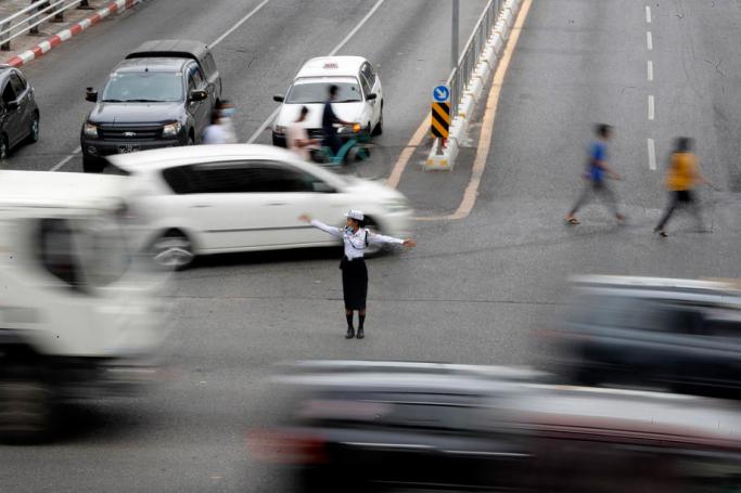 A photo taken with slow shutter speed shows a police woman directing traffic on a busy road in downtown Yangon, Myanmar, 18 May 2020. Photo: Nyein Chan Naing/EPA