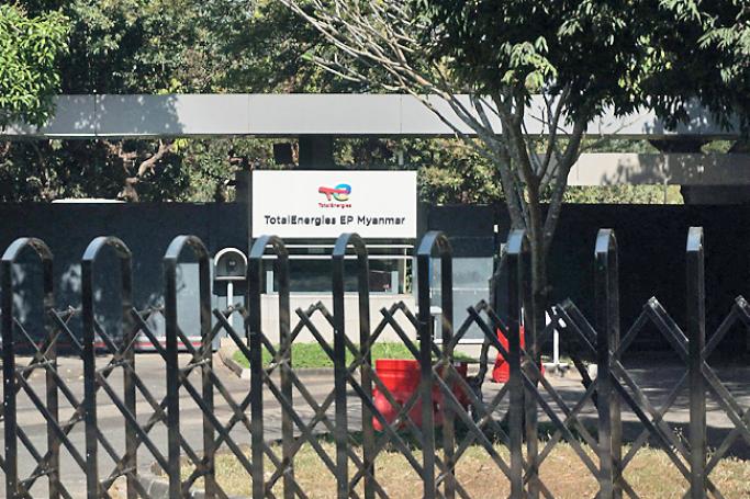 This file photograph taken on January 22, 2022, shows a signboard for TotalEnergies EP Myanmar past a shuttered gate in Yangon, after energy giants TotalEnergies and Chevron said they would leave Myanmar following pressure from human rights groups to cut financial ties with the junta since last year's military coup. Photo: AFP