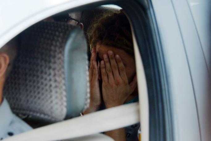 This photo taken on February 22, 2019 shows detained French tourist Arthur Desclaux covering his face while leaving in a police car after facing trial in Naypyidaw. Photo: Thet Aung/AFP