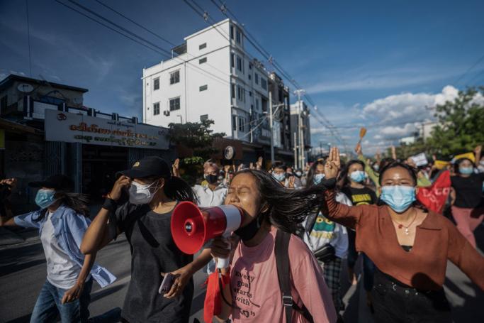 (File) Women protesters shout slogans and make the three-finger salute as they take part in a demonstration against the military coup in Mandalay on July 10, 2021. Photo: AFP