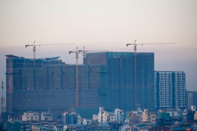 The construction of a high-rise building towers its neighborhood in Yangon. Photo: Lynn Bo Bo/EPA
