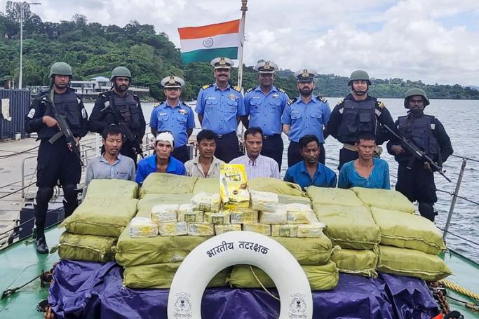 In this handout photograph taken by India's Ministry of Defence on September 19, 2019, Indian Coast Guard personnel (up) pose for photographs as they keep watch on a Myanmarese ship's crew after seizing 1160 kg of Ketamine drug from their boat near Car Nicobar islands, part of the Indian union territory of Andaman and Nicobar islands. Photo: AFP