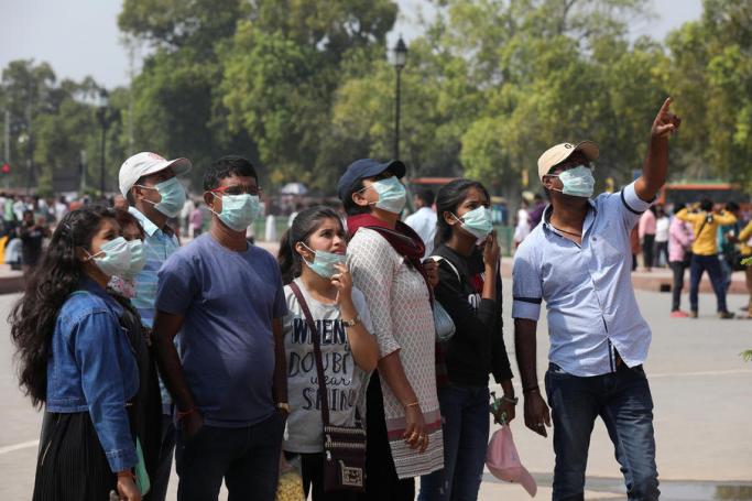 Tourists wear protective masks as a precaution against the coronavirus outbreak, at the India gate in New Delhi, India, 04 March 2020. Photo: EPA