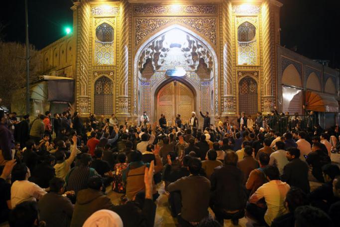 Iranians gathered to pray behind the closed door of Masumeh shrine in the city of Qom, Iran, 16 March 2020. Photo: EPA