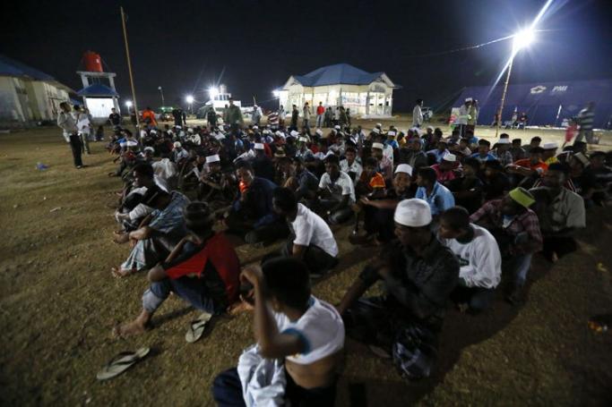Rohingya refugee are seen sitting on the ground as the security officer conduct a head count before bed time at their temporary camp in Kuala Cangkoi, in North Aceh, Indonesia, 01 June 2015. EPA/HOTLI SIMANJUNTAK
